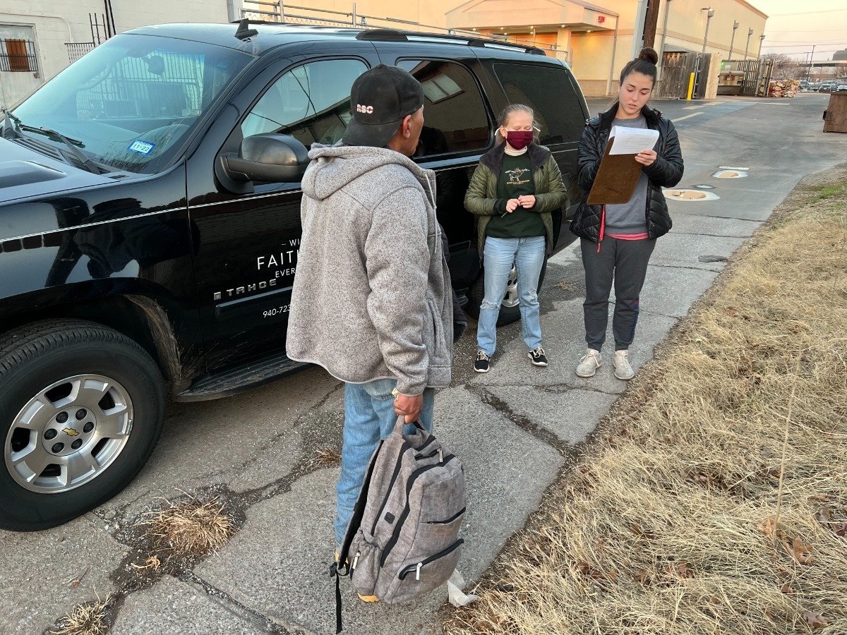 two officials taking information from man